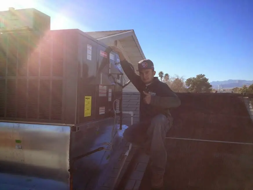 HVAC technician performing AC Tune-Up on a rooftop unit in Valley Park