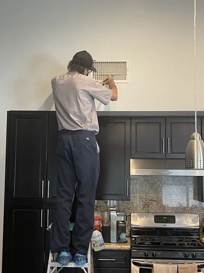 Technician inspecting an air vent during HVAC service in Valley Park